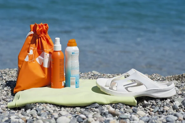 Zonneproducten crèmes op een strandhanddoek — Stockfoto