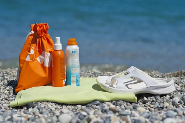 Crèmes solaires sur une serviette de plage — Photo