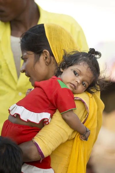 Индийская мама держит свою дочь на руке — стоковое фото