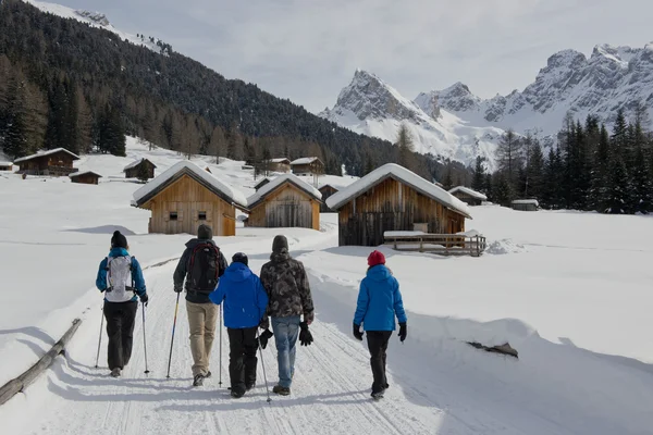 Groep wandelen op een besneeuwde parcours naar berghutten — Stockfoto