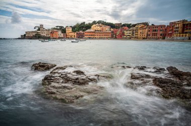 Renkli evleriyle eski Sestri Levante kasabası, İtalyan Rivierası 'nın en iyi mekanlarından biri olan Baia del Silenzio' ya bakıyor.