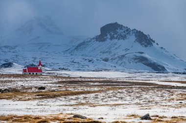 Hellisandur, İzlanda 'nın karlı manzarasında kırmızı çatılı beyaz kilise