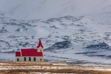 Hellisandur, İzlanda 'nın karlı manzarasında kırmızı çatılı beyaz kilise