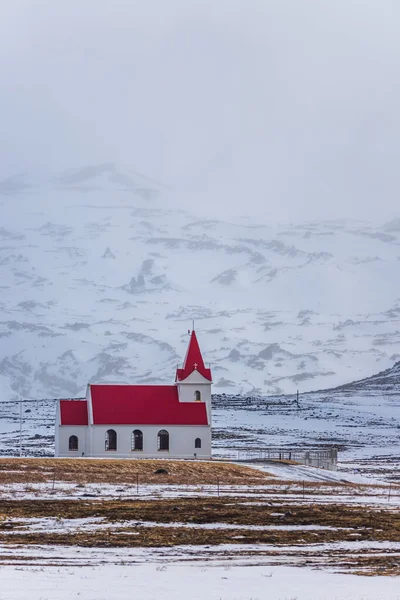 Hellisandur, İzlanda 'nın karlı manzarasında kırmızı çatılı beyaz kilise