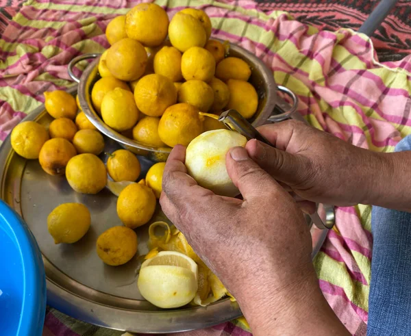 Soyulmuş limon soyan adam. Geleneksel ev yapımı limonata hazırlıyorum. ellere odaklan