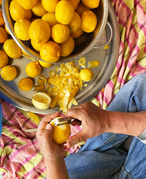 Soyulmuş limon soyan adam. Geleneksel ev yapımı limonata hazırlıyorum. ellere odaklan