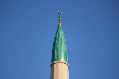 modern green minaret isolated on blue sky