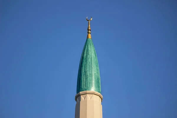 modern green minaret isolated on blue sky