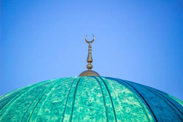 green mosque dome isolated on clean blue sky