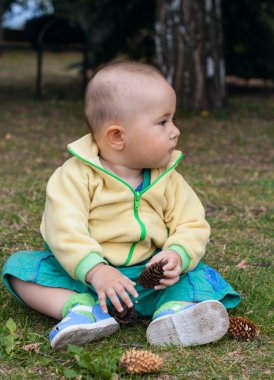 Bebek çim bir parkta otururken