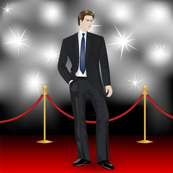 Man in suit posing in front of the paparazzi on the red carpet