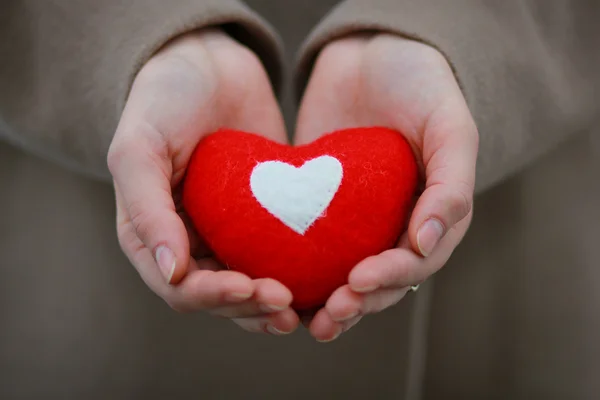 Coeur rouge dans les mains de la fille — Photo