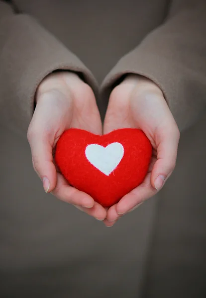 Corazón rojo en las manos de la chica — Foto de Stock