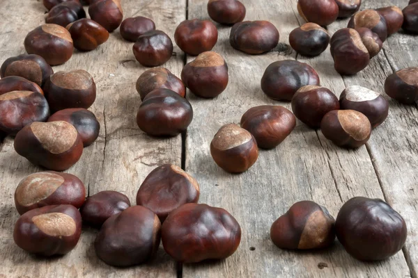 Closeup chestnuts on wooden desk — Stock Photo, Image