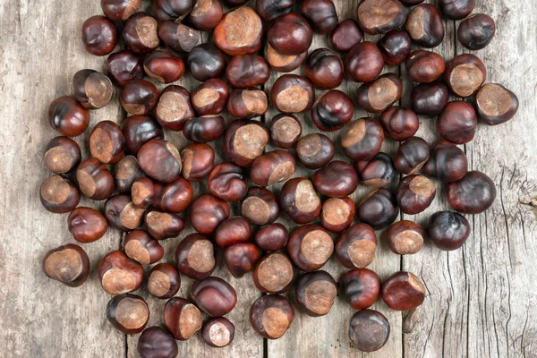 Closeup chestnuts on wooden desk — Stock Photo, Image