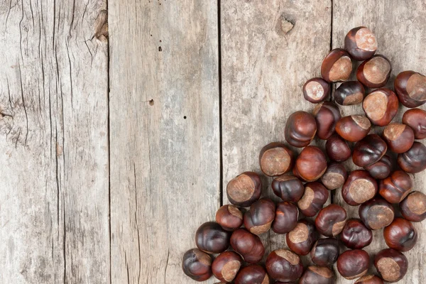 Closeup chestnuts on wooden desk — Stock Photo, Image