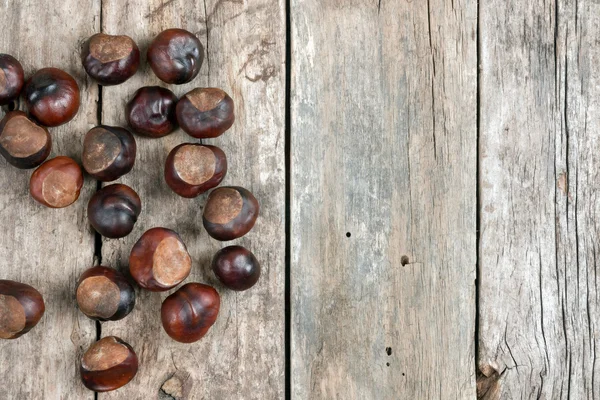 Closeup chestnuts on wooden desk — Stock Photo, Image