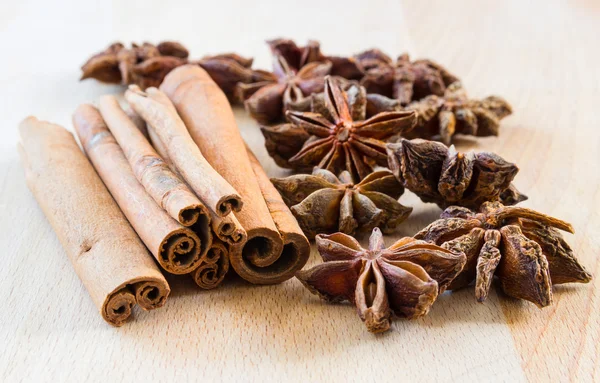 Macro plano de un anís estrellado y palos de canela en un respaldo de madera — Foto de Stock