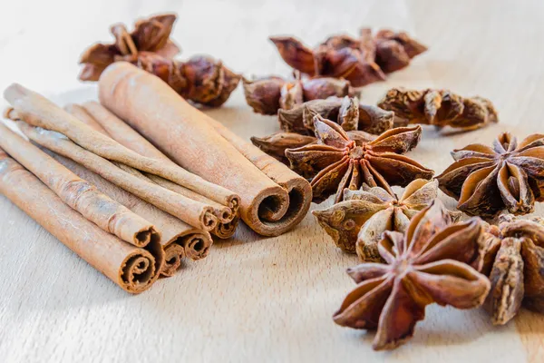 Macro plano de un anís estrellado y palos de canela en un respaldo de madera — Foto de Stock