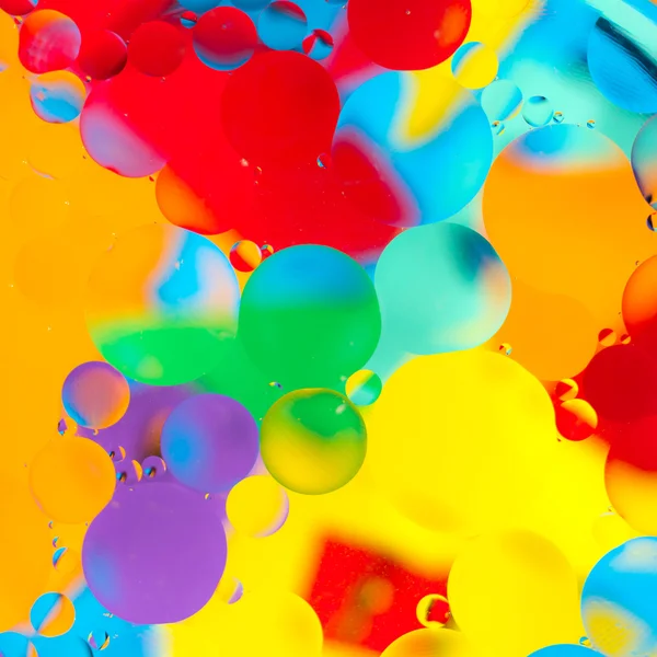 Oil drops in water on a coloured background — Stock Photo, Image