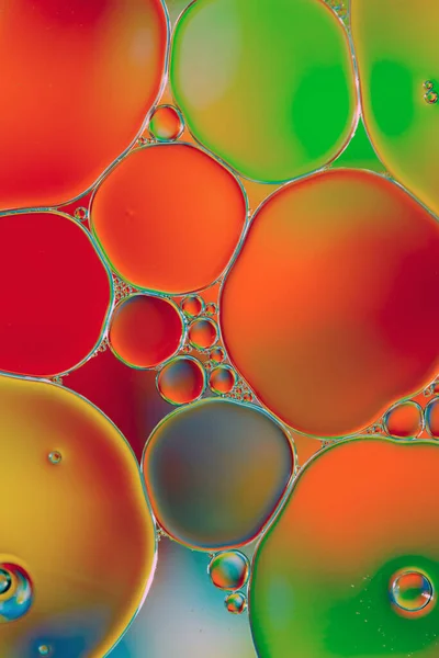 Oil drops in water on a coloured background.