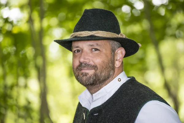 Man with Bavarian traditional black hat iin forest — Stock Photo, Image