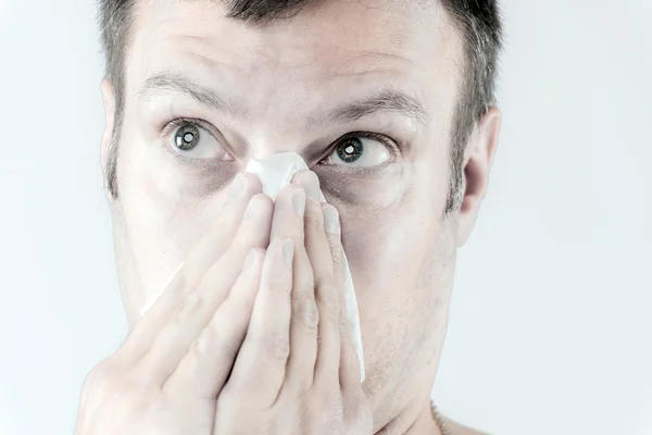 Человек с гриппом чихает. — стоковое фото