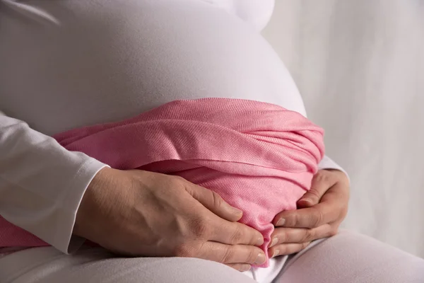 Pregnant woman is holding her baby bump — Stock Photo, Image