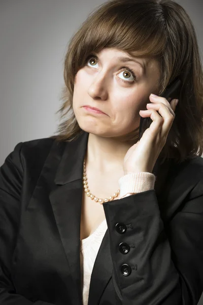 Zakelijke vrouw wonderen op mobiele telefoon — Stockfoto