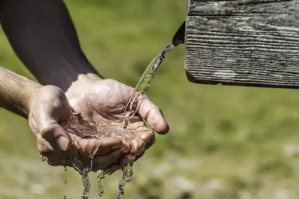 Dorst handen nemen water uit put — Stockfoto