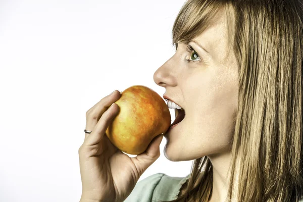 Chica joven mordiendo en manzana — Foto de Stock