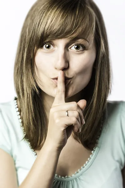 Young woman holds a finger to her mouth — Stock Photo, Image