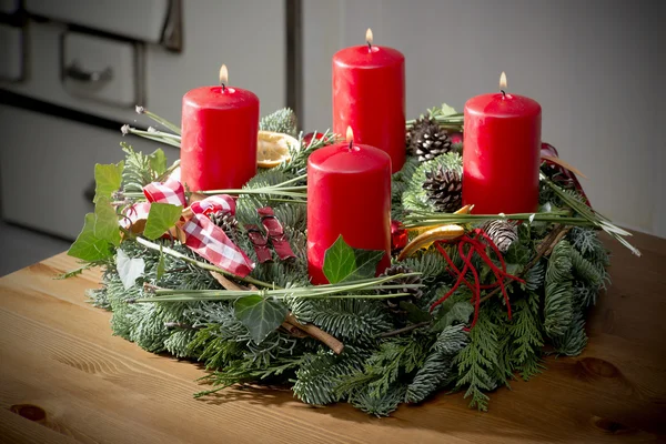 Corona de Adviento con velas rojas encendidas — Foto de Stock