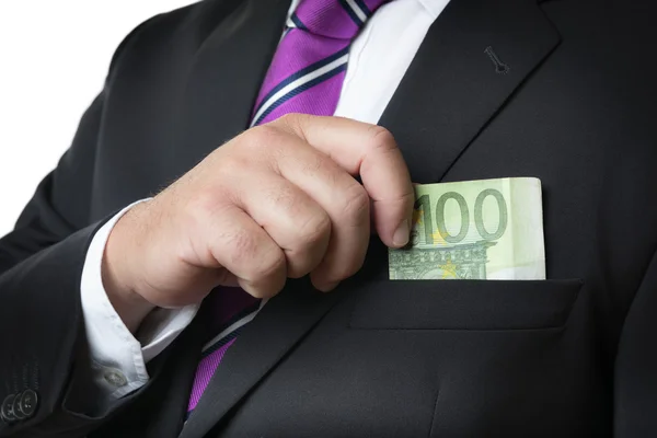 Businessman putting money in pocket — Stock Photo, Image