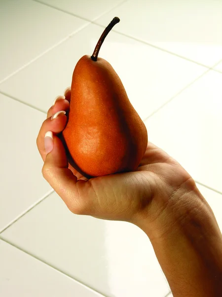 Woman hand holding pear — Stock Photo, Image