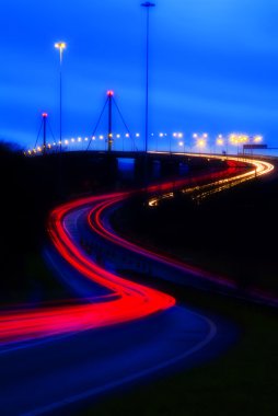 Gece karayolu köprüsünde hafif trafik izleri var.