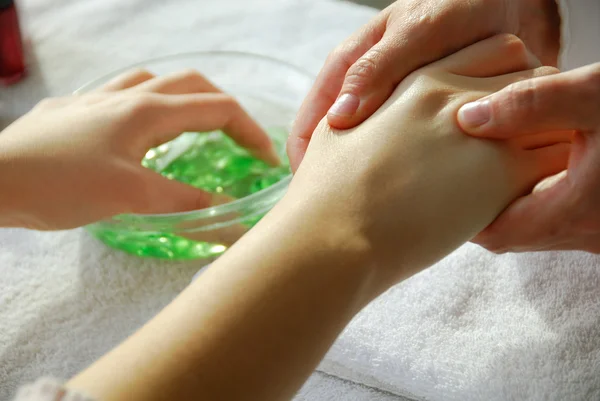 Mujer en un salón de uñas recibiendo una manicura, ella está recibiendo un masaje de manos — Foto de Stock