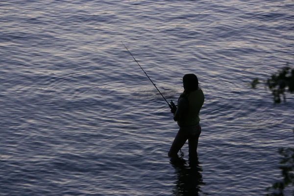 Woman fishing in river