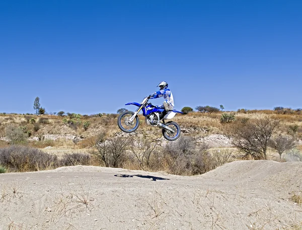 Una foto de un motociclista haciendo un truco y salta en el aire — Foto de Stock