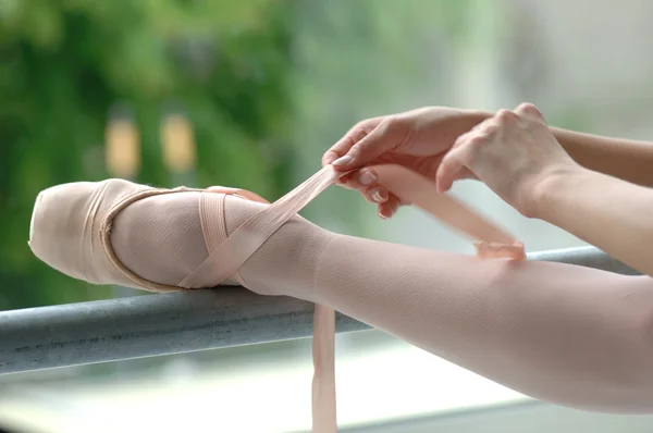 Ballerina putting on pointe shoes — Stock Photo, Image