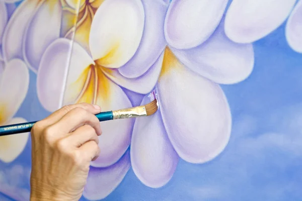 Une artiste féminine peignant des fleurs — Photo