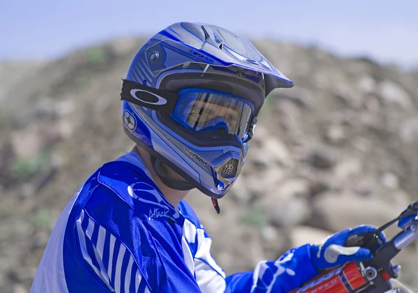 Driver goes downhill leaving a trail of dust with his motocross bike — Stock Photo, Image