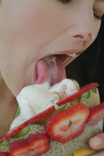 Красивая женщина наслаждается фруктовым десертом с мороженым — стоковое фото