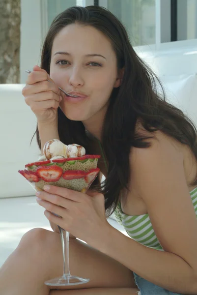 Beautiful woman enjoying fruit dessert with icecream — Stock Photo, Image