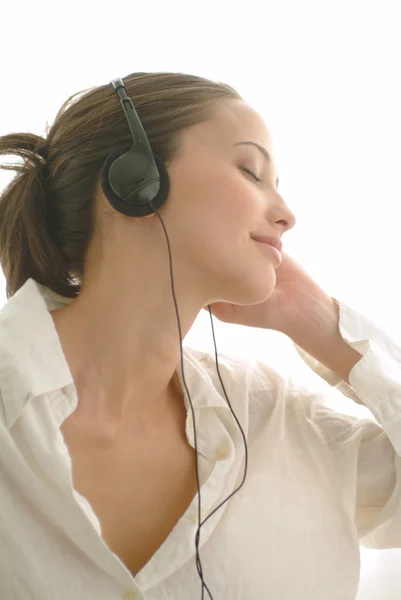 Schöne Mädchen hören Musik im Bett — Stockfoto