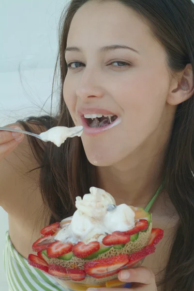 Beautiful woman enjoying fruit dessert with icecream — Stock Photo, Image