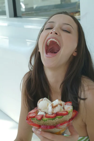 Beautiful woman enjoying fruit dessert with icecream — Stock Photo, Image