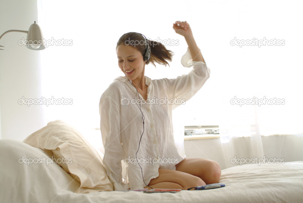 Beautiful Girl listening music in bed