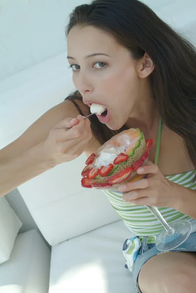 Beautiful woman enjoying fruit dessert with icecream — Stock Photo, Image