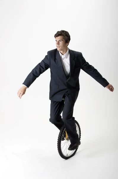 Businessman riding unicycle — Stock Photo, Image